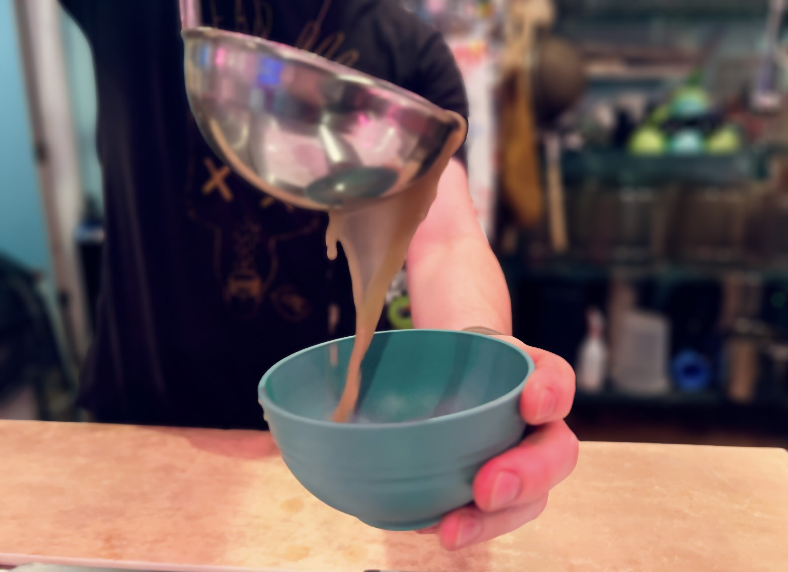 Kavatender pouring a shell of Kava at Denver's Favorite Kava Bar